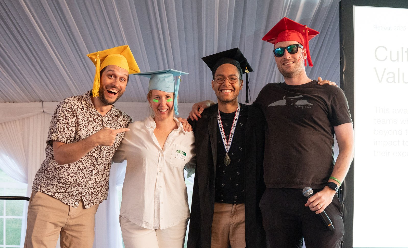 Alloy teammates in graduation caps celebrating on stage